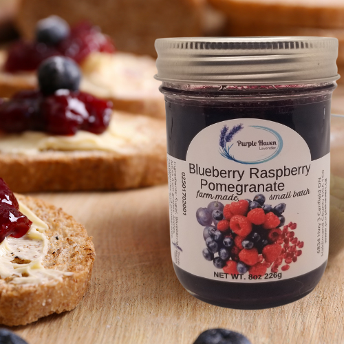 Artisan Blueberry Raspberry Pomegranate Jam from Purple Haven, perfect for spreading on fresh bread. Enjoy local flavors!
