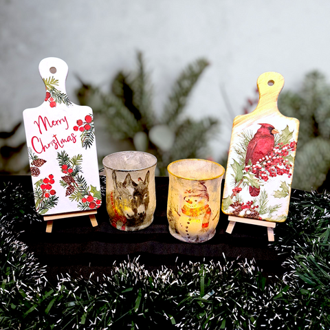 Christmas decoupage workshop decor: two festive boards with holly and cardinal, plus two candle holders.