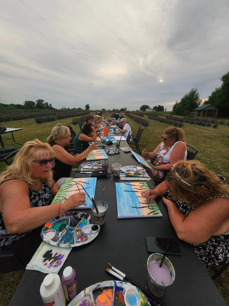 Participants enjoying the Sunflower Harvest Paint event, creating art amidst a vibrant lavender field.